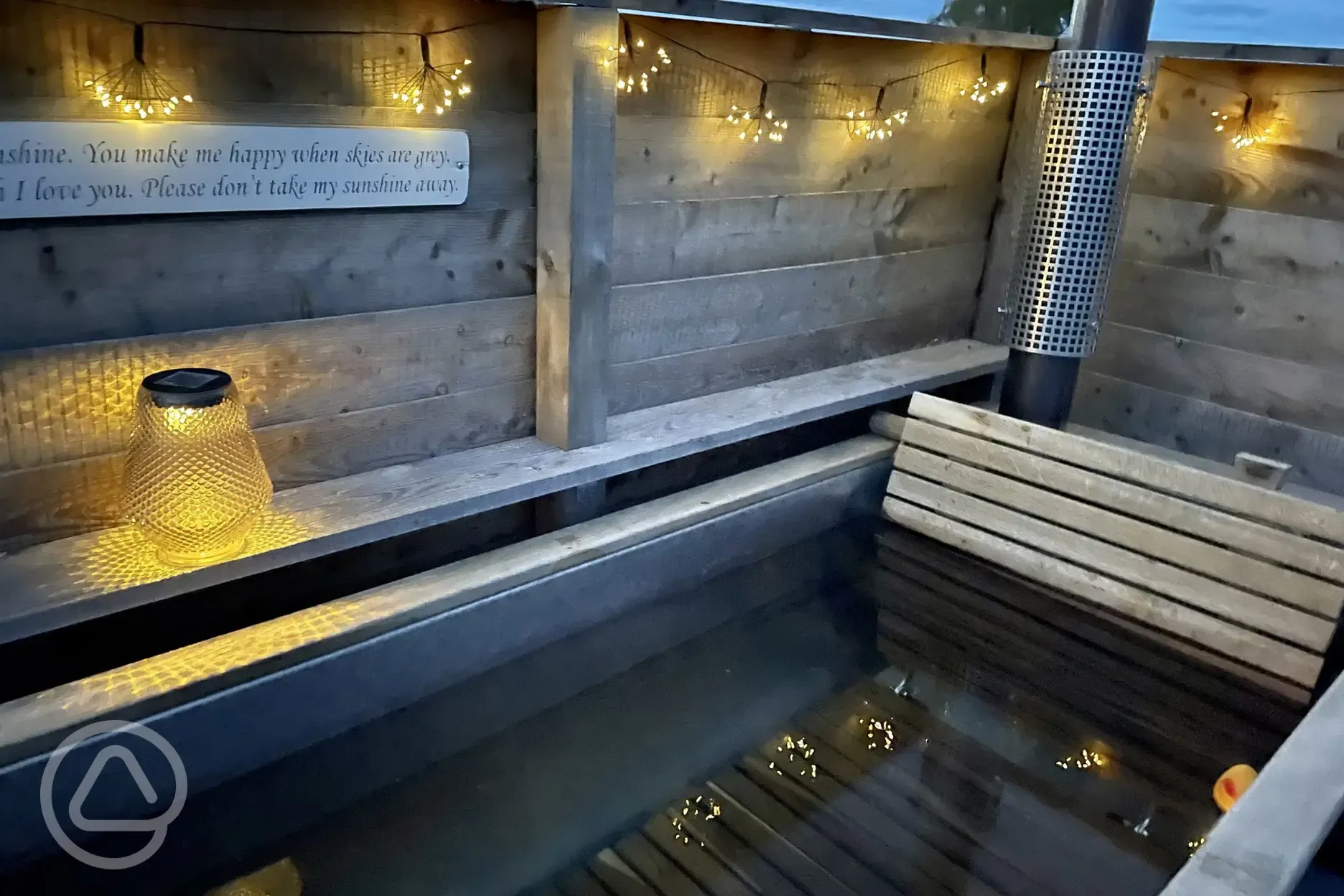 Luxury ensuite glamping pod with an outdoor bath at night