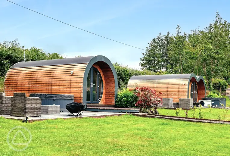 Glamping pods with private patios, outdoor furniture and hot tubs