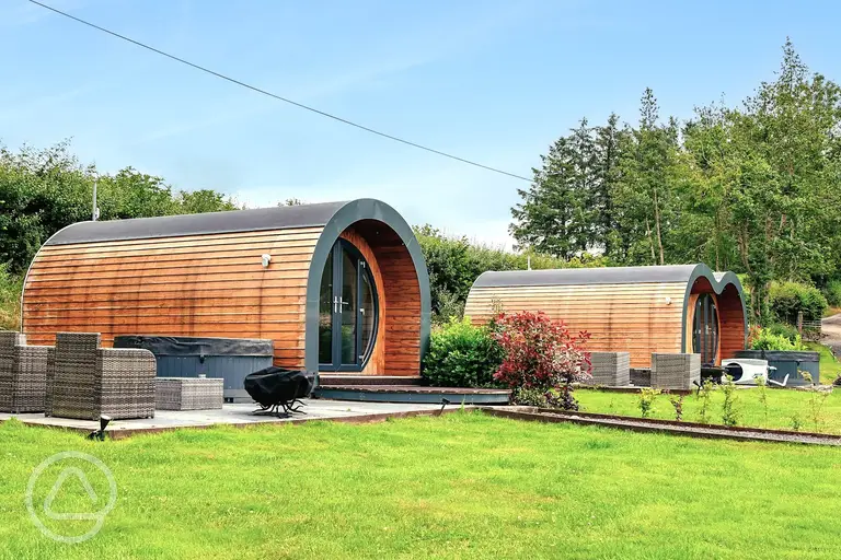 Glamping pods with private patios, outdoor furniture and hot tubs