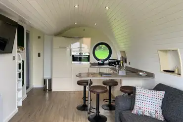 Wye glamping pod interior with a kitchen, sofa and breakfast bar