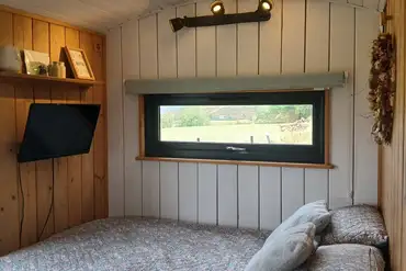 Shepherd's hut bed and tv at Cae Main 