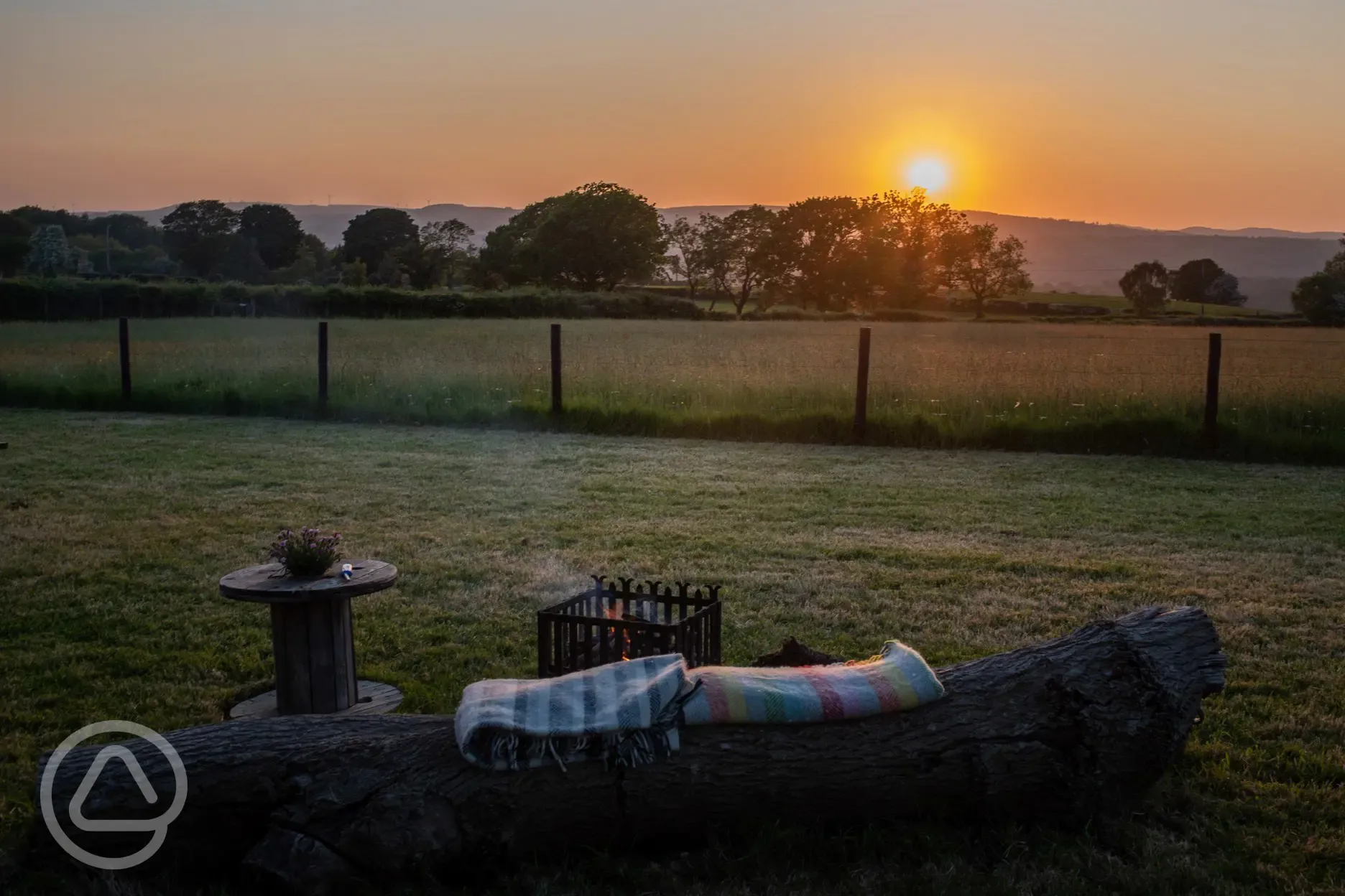 Shepherd's hut outdoor seating at sunset