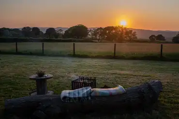 Shepherd's hut outdoor seating at sunset