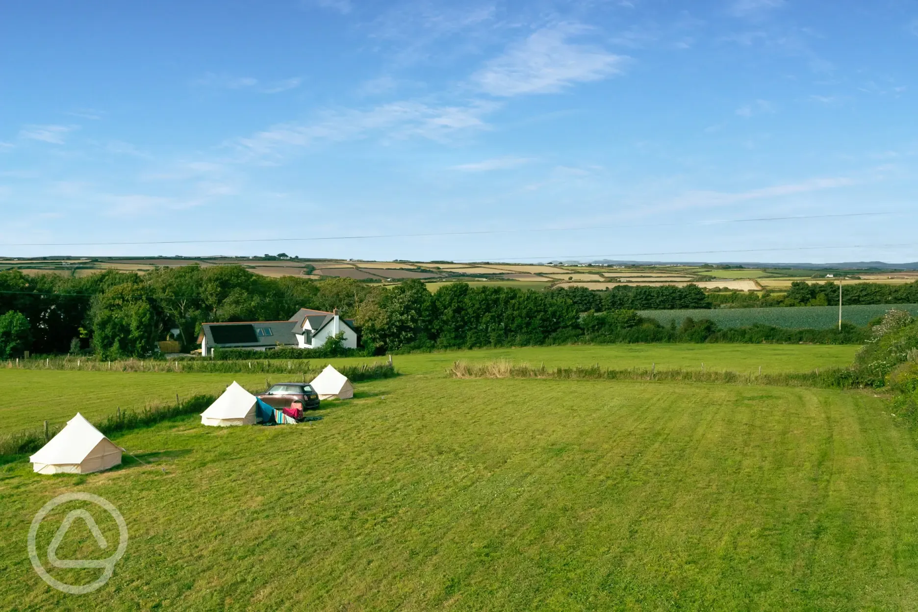 Grass field with view and bell tents