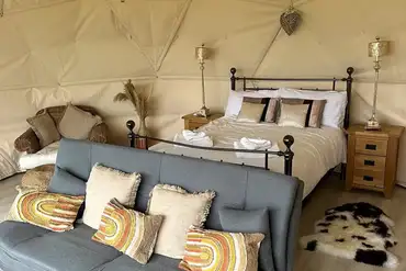 Double bed, futon, and bedside table inside the 4m geodome