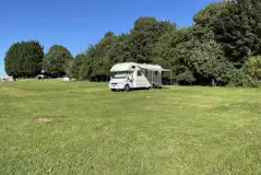 A campervan with an awning on the grass touring pitches with optional electric A campervan with an awning on the grass touring pitches with optional electric