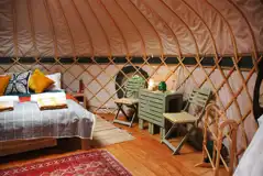 Orchard yurt interior with a king size bed and bedding