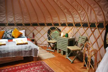 Orchard yurt interior with a king size bed and bedding