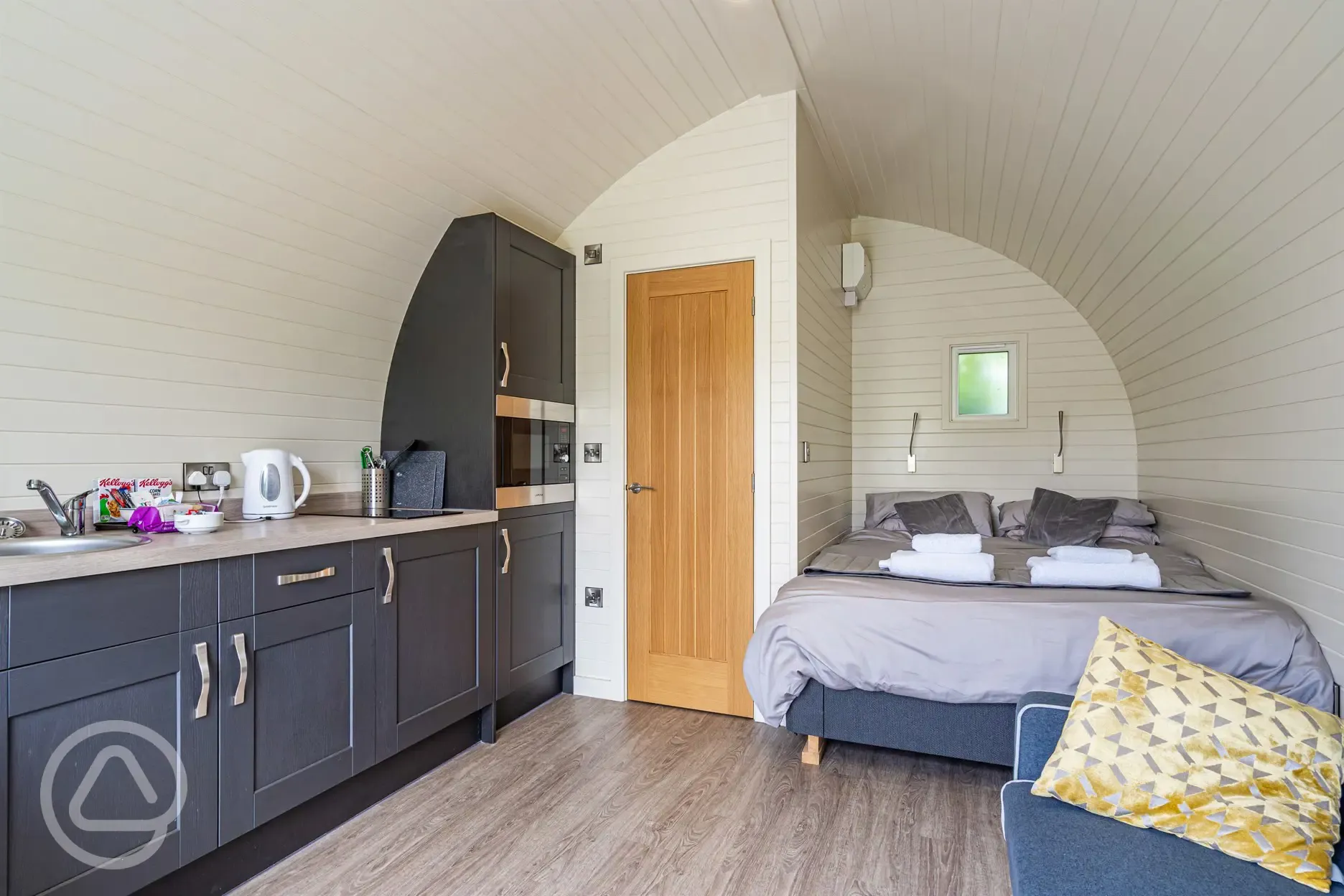 Kitchenette and double bed in the ensuite glamping pod at Church House