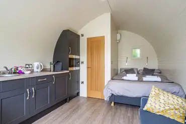 Kitchenette and double bed in the ensuite glamping pod at Church House