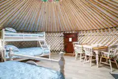 Mighty Oak yurt triple bunk bed and dining area