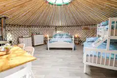 Mighty Oak yurt interior with a king size bed and triple bunk bed