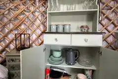 Horse Chestnut yurt kitchen cupboard equipped with crockery and cutlery