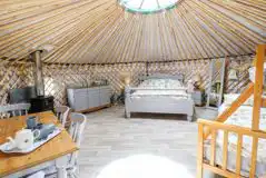 Silver Birch yurt interior with a king size bed and triple bunk bed