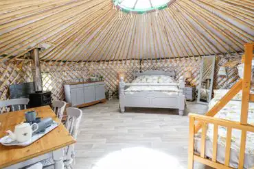 Silver Birch yurt interior with a king size bed and triple bunk bed