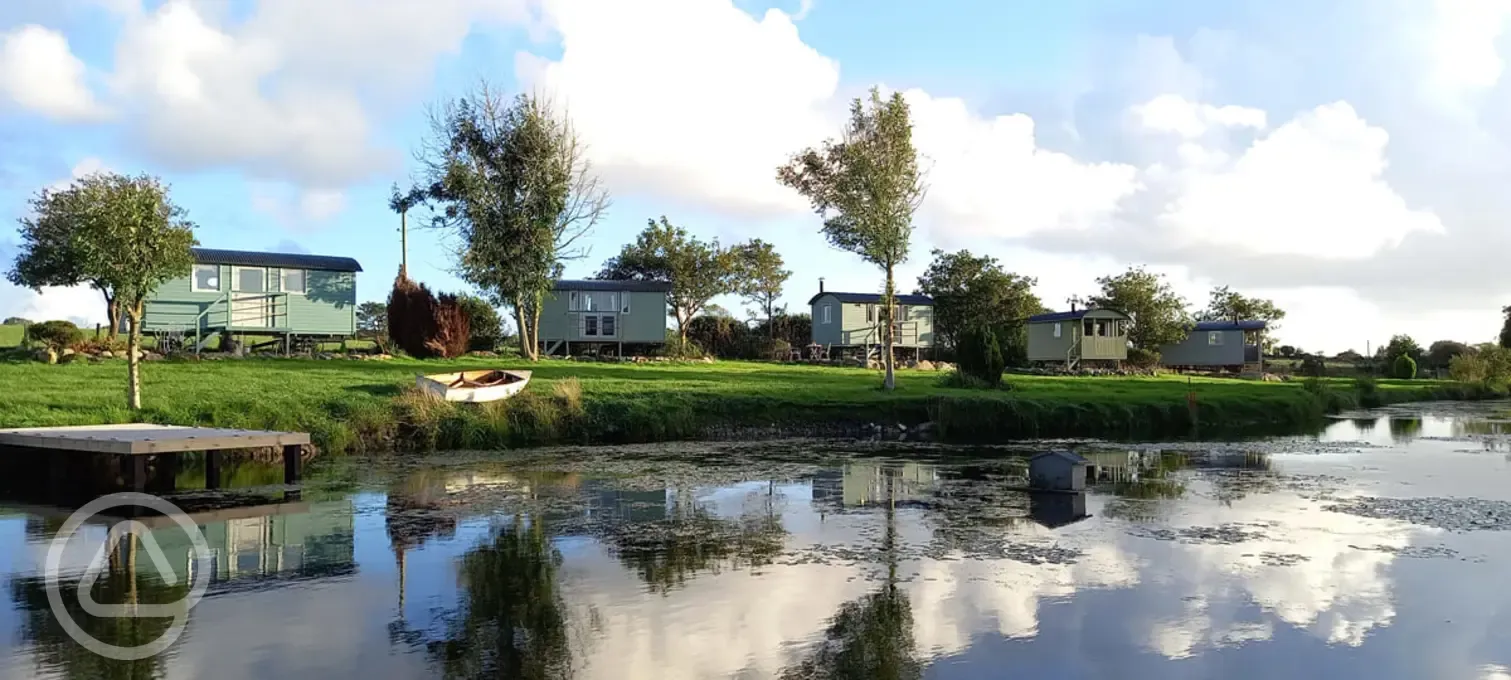 Shepherd's huts across the lake