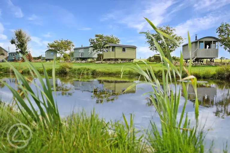 Shepherd's huts across the lake