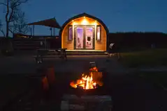 Glamping pods at night with fire pits Glamping pods at night with fire pits