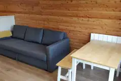 The Den and Roost glamping pod seating and dining area with sofa bed