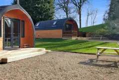 The Den and Roost glamping pod exteriors and decking, with outdoor seating