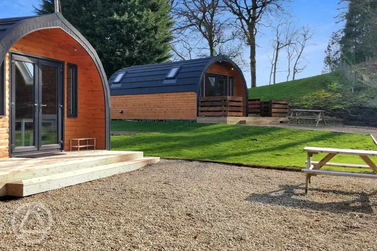 The Den and Roost glamping pod exteriors and decking, with outdoor seating