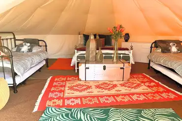 Bell tent interior with a double bed, two single beds and two trundle beds