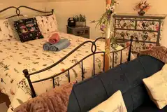 Boreal Belle interior with a king size bed, sofa bed, table, chairs and storage