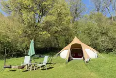 Private seating areas outside the bell tents with fire pits and hammocks