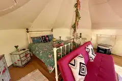 Bubo Belle interior with a king size bed table, chair, storage and kitchenware