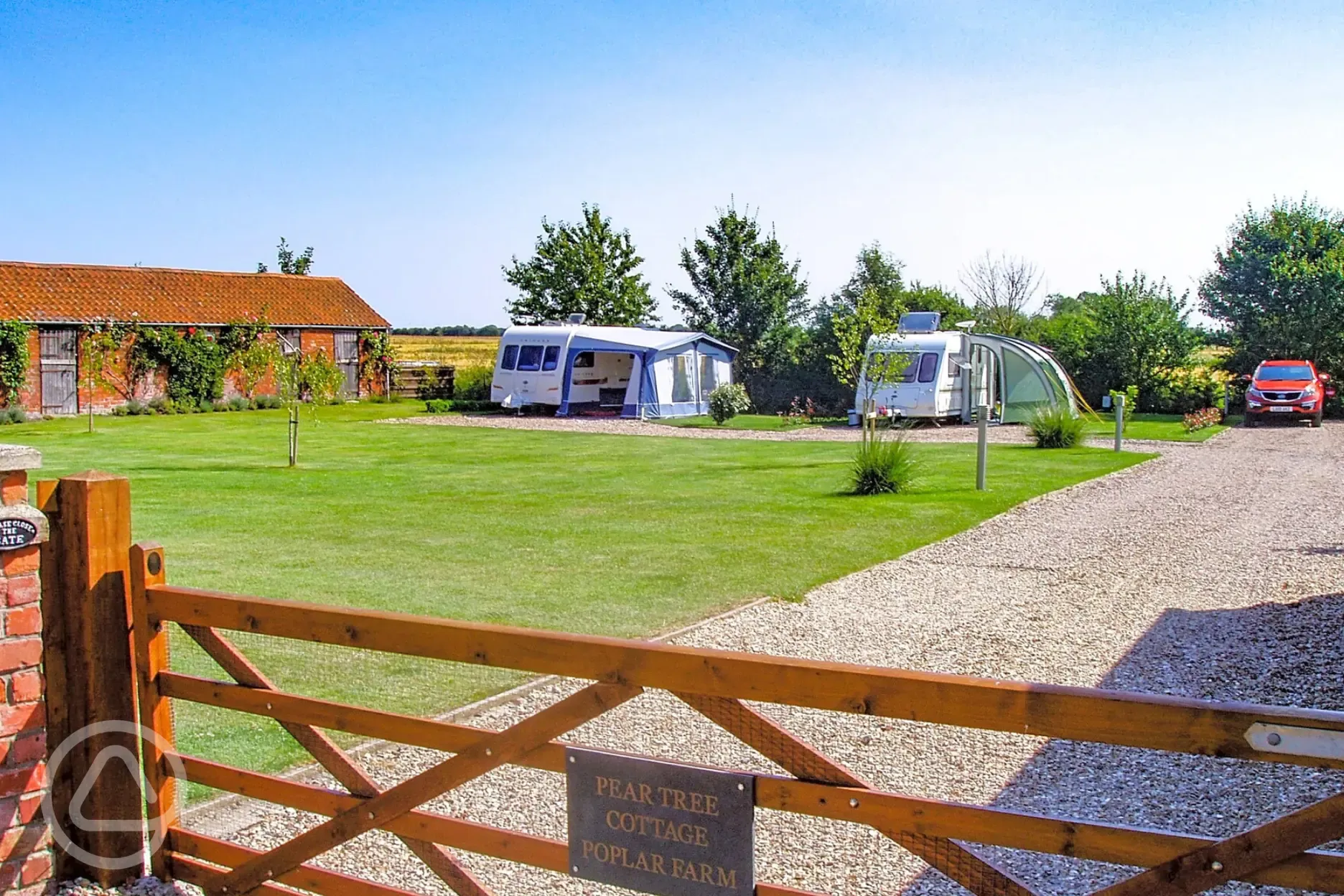 View over the gate of the hardstanding pitches at Pear Tree Cottage