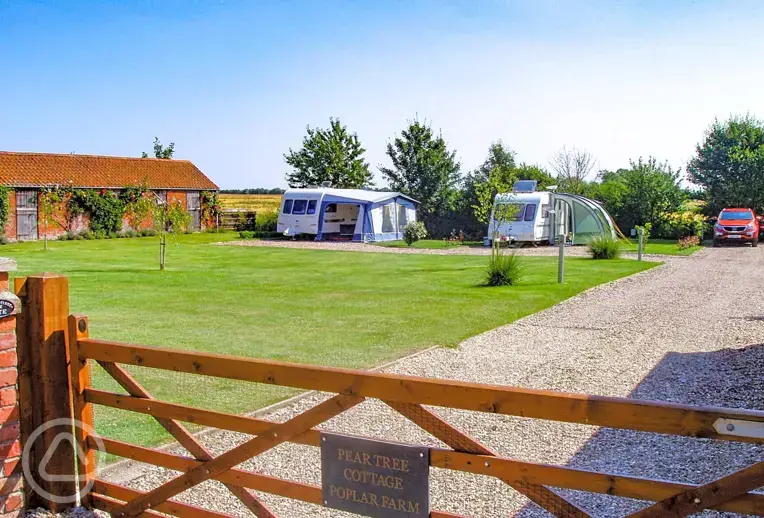 View over the gate of the hardstanding pitches at Pear Tree Cottage