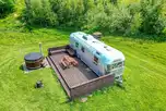 Big Bertha Airstream caravan with a wood-fired hot tub and deck area
