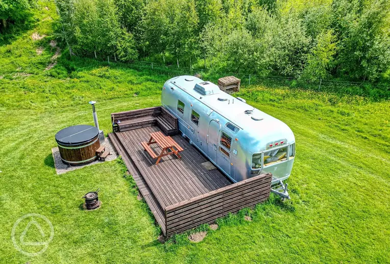 Big Bertha Airstream caravan with a wood-fired hot tub and deck area