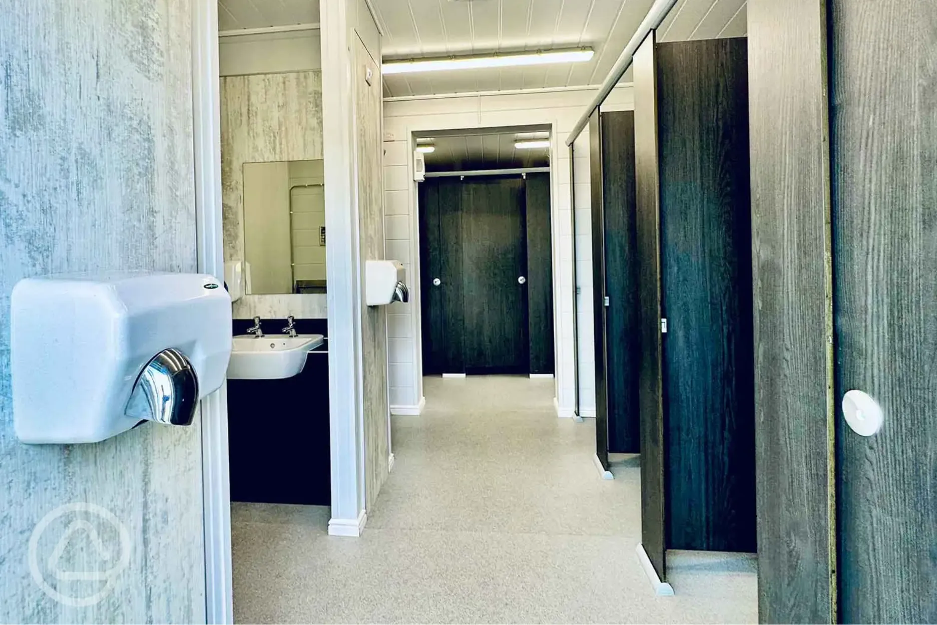 Toilets and showers with hand dryers, mirrors and sinks