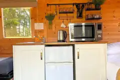 Shepherd's hut kitchen with a fridge/freezer, microwave, kettle and sink Shepherd's hut kitchen with a fridge/freezer, microwave, kettle and sink