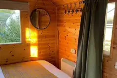 Shepherd's hut double bed with a radiator and hooks for storage Shepherd's hut double bed with a radiator and hooks for storage