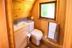 Ensuite glamping pod bathroom with toilet, sink, shower and heated towel rail