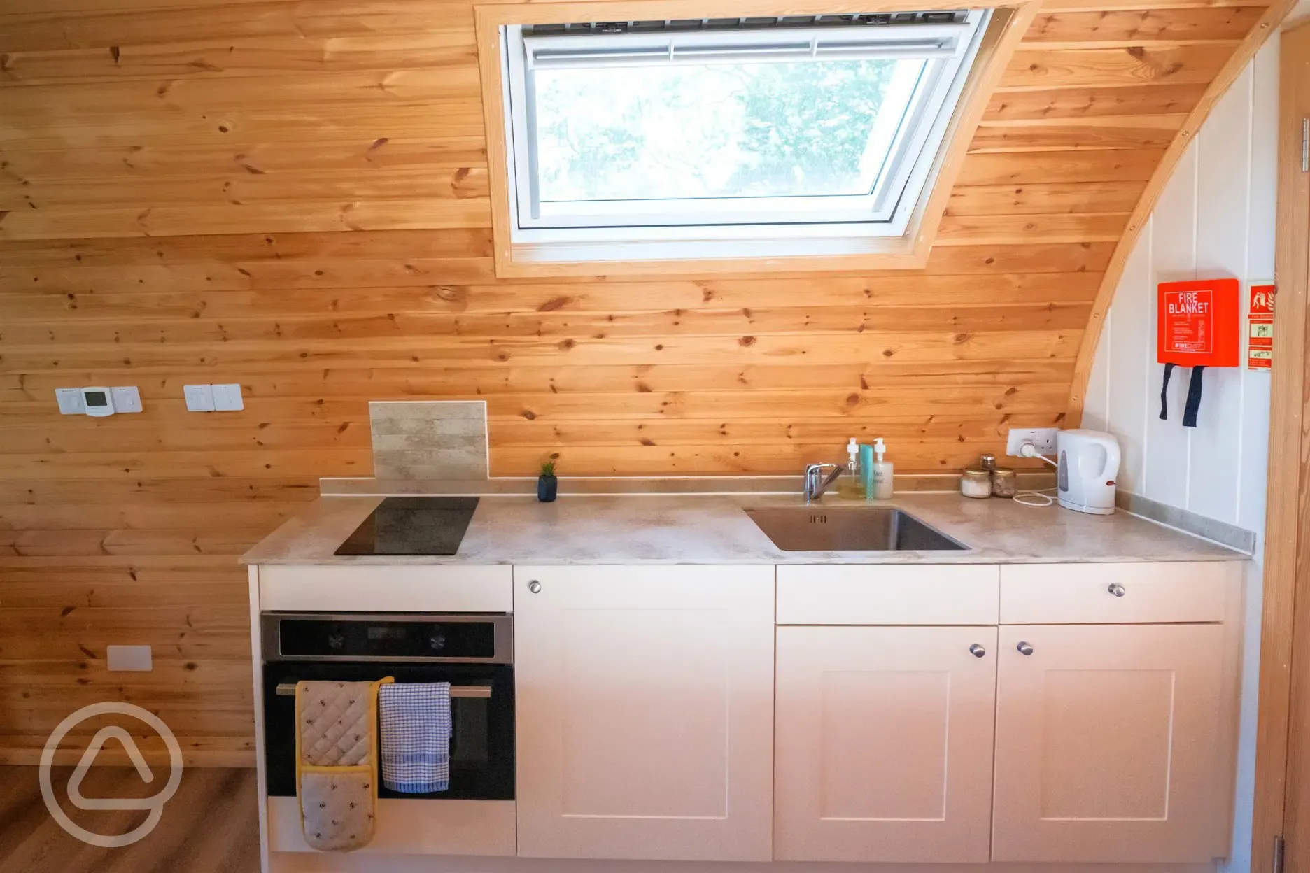 Ensuite glamping pod kitchen with fridge/freezer, kettle, oven, hob and crockery