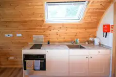 Ensuite glamping pod kitchen with fridge/freezer, kettle, oven, hob and crockery
