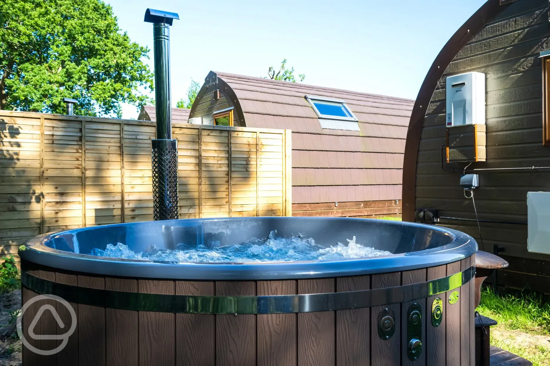 Wood fired hot tub in a private area behind the pod