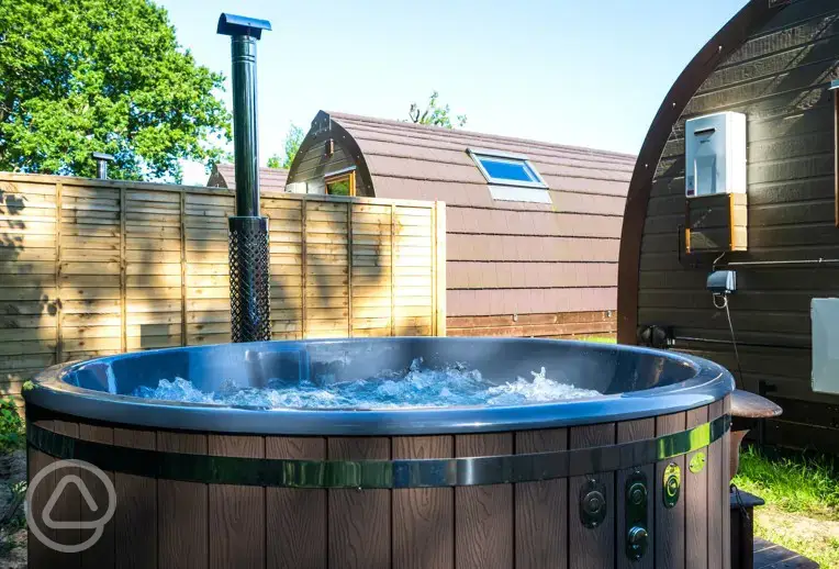 Wood fired hot tub in a private area behind the pod