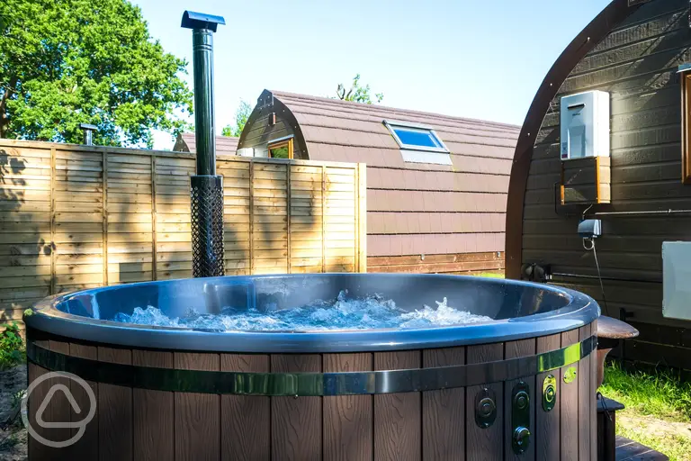 Wood fired hot tub in a private area behind the pod