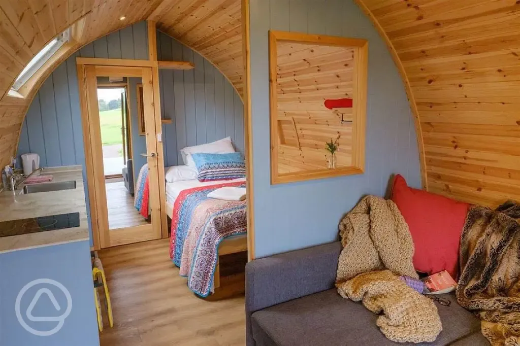 Ensuite glamping pod interior with double bed, kitchenette and living area
