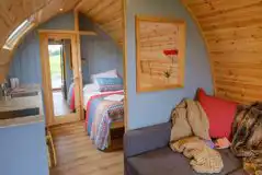 Ensuite glamping pod interior with double bed, kitchenette and living area