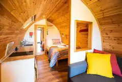 Ensuite glamping pod interior with double bed, kitchenette and living area