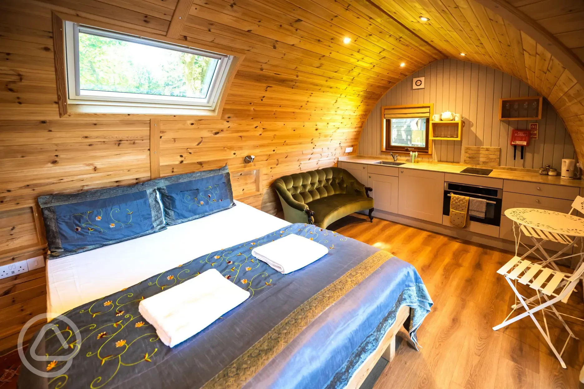 Primate pod interior with double bed, kitchenette and seating