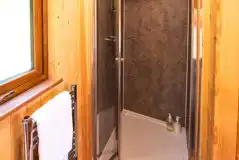 Ensuite glamping pod bathroom with toilet, sink, shower and heated towel rail