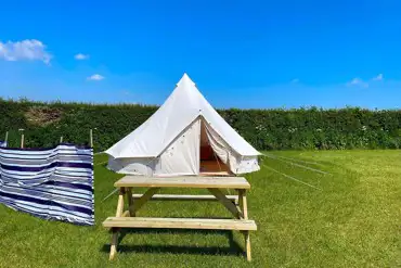 Bell tent with a picnic table and windbreak