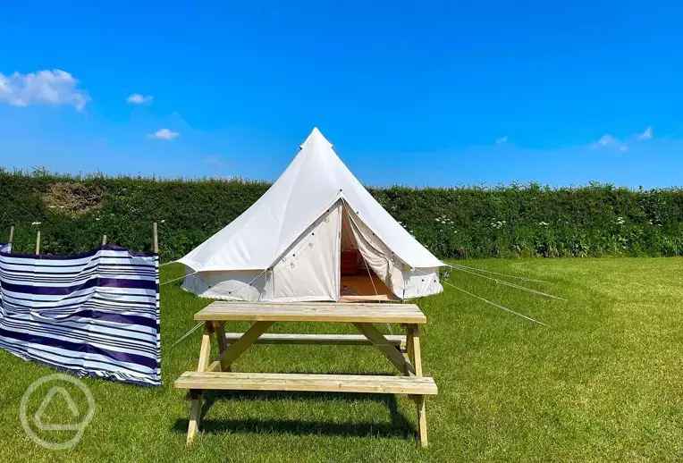 Bell tent with a picnic table and windbreak