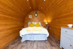 Camping pod interior with a double and bedding